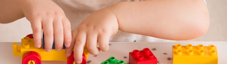 A child's hands, playing with colourful building blocks