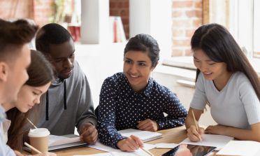 Five young people work around a table together