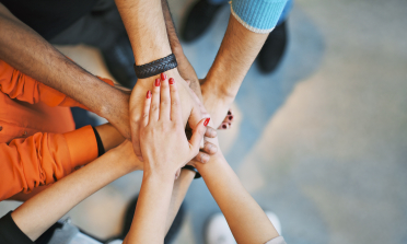 Six people's hands joined together