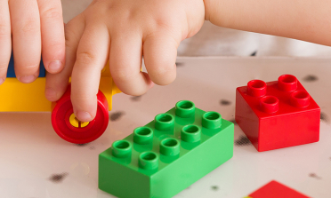 A child's hands playing with colourful bricks