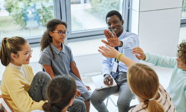 image of teacher and pupils in discussion