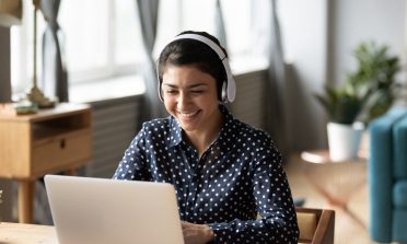 A woman working at a computer wearing headphones