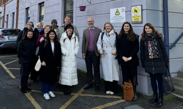 A group of people stand outside a school building