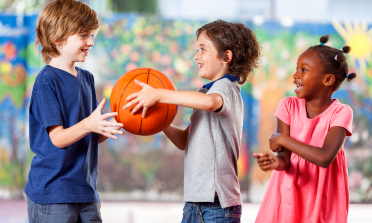 boy offering a ball to another child