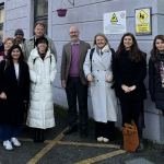 A group of people stand outside a school building